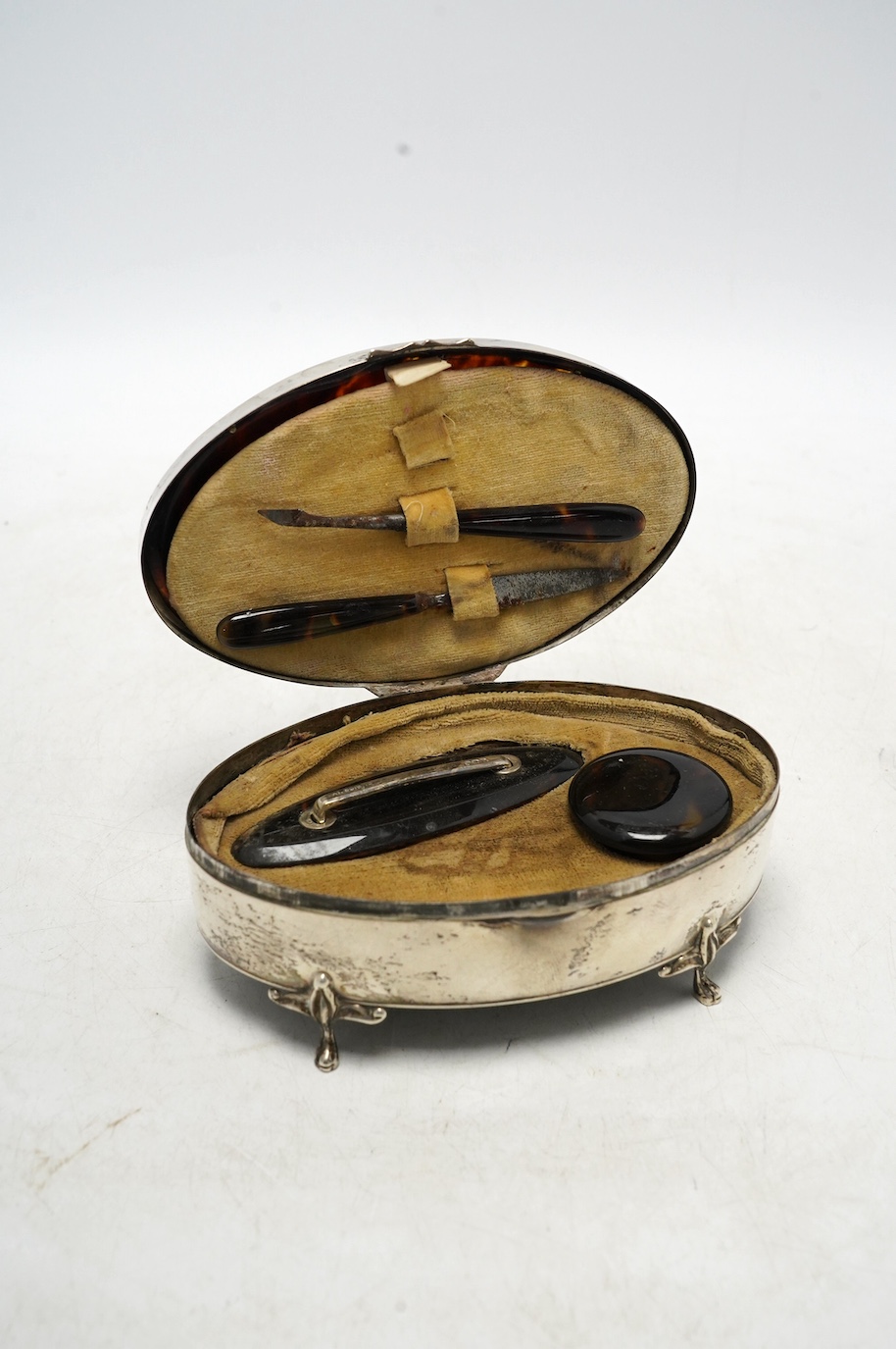 A George V silver and tortoiseshell mounted oval manicure box, E.S. Barnsley & Co Ltd, Birmingham, 1912, 13.5cm, incomplete. Condition - poor